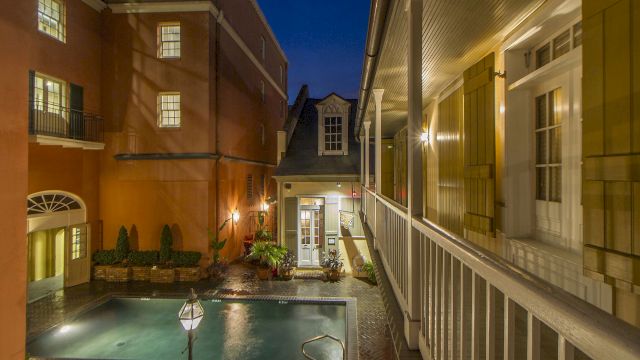 a courtyard with a pool and buildings at night